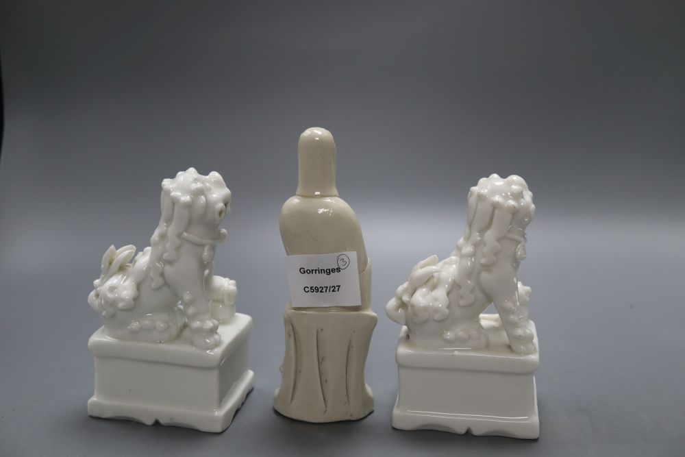 A pair of Chinese blanc de chine lion-dogs and a similar group of Guanyin, height 17cm